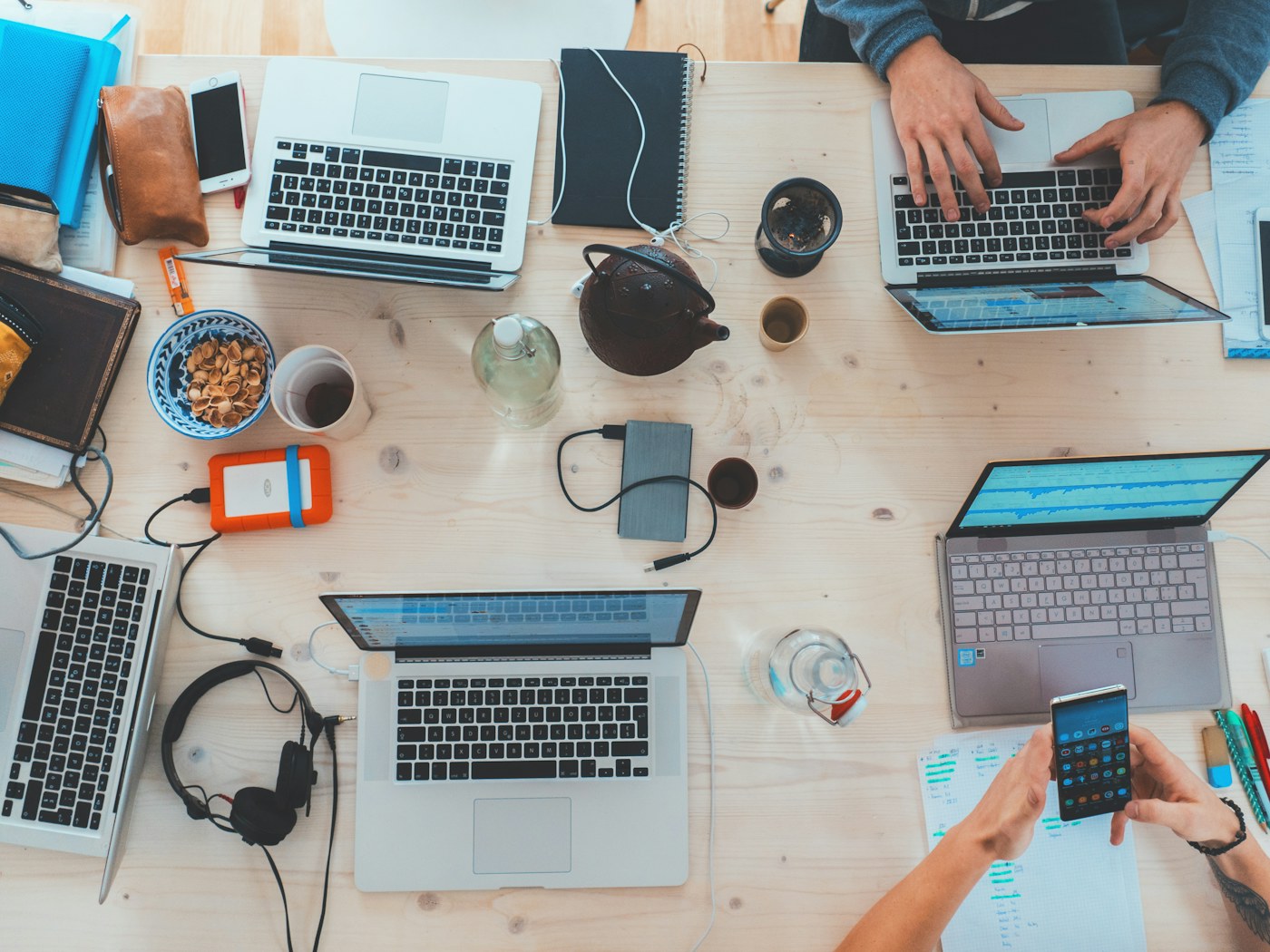 Laptops and work materials arranged around a shared workspace